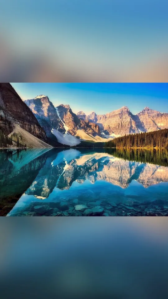 A finished vertical video: a mountain lake shown whole over a soft, blurred copy of itself